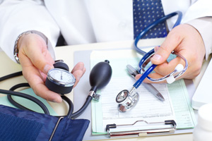 A male Physician is holding sphygmomanometer and a stethoscope in his hands